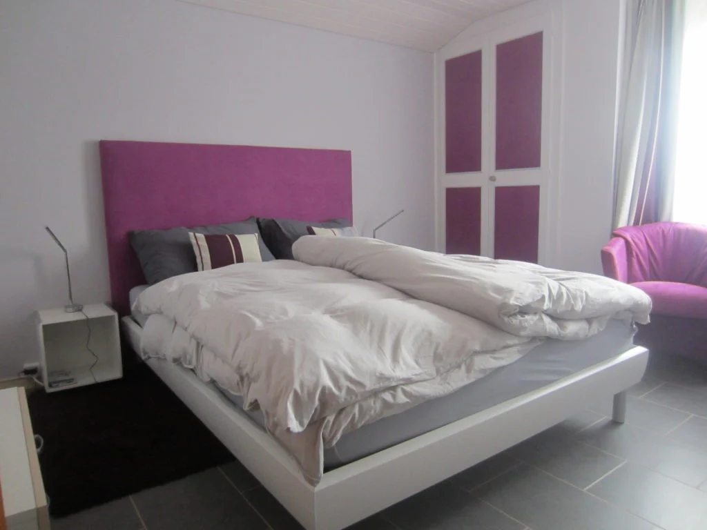 Chambre double aux tons roses au Café-Restaurant Les Cluds.